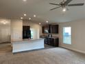 Open kitchen features an island, dark cabinets, and stainless steel appliances at 4306 Sagefield Dr, Harmony, FL 34773
