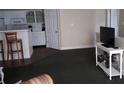 Spacious living room with dark carpet and a view into the kitchen at 4113 Enchanted Oaks Cir # 1216, Kissimmee, FL 34741