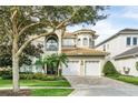 Elegant two-story home with a three-car garage and lush landscaping at 364 Muirfield Loop, Reunion, FL 34747