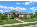 One-story home with stucco exterior, landscaping, and walkway at 8747 Bridgeport Bay Cir, Mount Dora, FL 32757