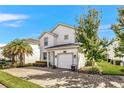 Two-story house with a white exterior and a two car garage at 4782 Kings Castle Cir, Kissimmee, FL 34746