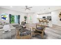 Open-concept living room and kitchen with modern appliances and wood-look floors at 250 S Virginia Ave, Deland, FL 32724