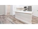 Modern kitchen with white cabinetry, quartz countertops, and stainless steel appliances at 250 S Virginia Ave, Deland, FL 32724
