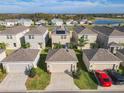 Aerial view showcasing a community of homes with solar panels and garages at 13041 Inkwell Aly, Winter Garden, FL 34787