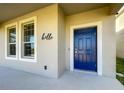 Inviting home exterior featuring a stylish blue front door and neutral color palette at 13041 Inkwell Aly, Winter Garden, FL 34787