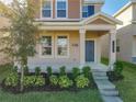 Two-story house with taupe and brown siding, landscaping, and a front porch at 13041 Inkwell Aly, Winter Garden, FL 34787