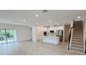 Open living room with kitchen and staircase at 2949 Sunset Dr, New Smyrna Beach, FL 32168
