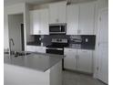 Modern kitchen with stainless steel appliances and gray countertops at 3025 Ballad Rd, Kissimmee, FL 34746