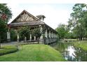 Covered bridge entrance to a community with a pond at 25822 Feather Ridge Ln, Sorrento, FL 32776