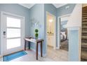 Bright entryway with light blue walls, tile floors, and a view of the staircase and bathroom at 740 Pebble Beach Dr, Davenport, FL 33896