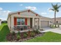 House exterior with a two-car garage and front porch at 12965 Trovita Dr, Grand Island, FL 32735