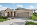 House exterior with a two-car garage and front porch at 12965 Trovita Dr, Grand Island, FL 32735