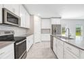 Modern kitchen with white cabinets, stainless steel appliances, and gray countertops at 2844 Alder Berry Blvd, Ocoee, FL 34761