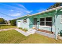 Light teal house with a well-manicured lawn and a gray walkway leading to the entrance at 2811 Vine St, Orlando, FL 32806