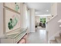 Bright and spacious foyer with glass-top console table and statement art at 2932 Waterlily Way, Poinciana, FL 34759