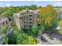 Aerial view of condo building with lush landscaping at 7658 Whisper Way # 402, Reunion, FL 34747