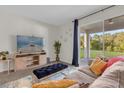 Bright living room with sliding glass doors leading to backyard, comfy seating and large TV at 212 Golden Sands Cir, Davenport, FL 33837