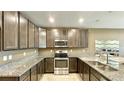 L-shaped kitchen with dark brown cabinets and granite countertops at 301 Primrose Dr, Davenport, FL 33837