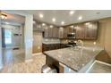 Modern kitchen with dark cabinets, granite countertops, and stainless steel appliances at 301 Primrose Dr, Davenport, FL 33837