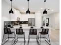 Modern kitchen with white cabinets, black accents, and breakfast bar with four stools at 4625 Target Blvd, Kissimmee, FL 34746