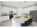 Modern kitchen with white cabinets and granite island at 1217 Happy Forest Loop, Deland, FL 32720