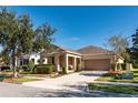 House exterior showcasing a two-car garage, neatly trimmed hedges, and a welcoming front porch at 12777 Bosworth Ave, Windermere, FL 34786