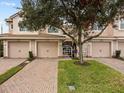 Townhome complex featuring brick driveways and lush landscaping at 8362 Bella Tierra Ct, Davenport, FL 33896