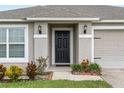 Black front door entry with landscaping and light fixtures at 205 Bella Verano Way, Davenport, FL 33897