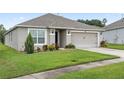 Single-story house with a two-car garage and well-maintained lawn at 205 Bella Verano Way, Davenport, FL 33897