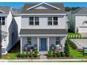 Two-story house with gray siding, blue door, rocking chairs on porch at 5562 Stockade Blvd, Saint Cloud, FL 34771