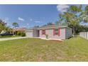 Gray house with red shutters, two-car garage, and grassy yard at 319 St Cloud Rd, Poinciana, FL 34759