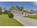 Gray house with red shutters, two-car garage, and a driveway at 319 St Cloud Rd, Poinciana, FL 34759