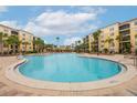 Relaxing community pool with surrounding lounge chairs and building views at 8815 Worldquest Blvd # 103 In Building 3, Orlando, FL 32821