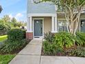 Townhouse entryway with gray door and landscaping at 594 Piazza Pt, Oviedo, FL 32765