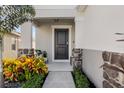 Inviting front entry with stone accents and lush landscaping at 1008 Overlook Ct, Davenport, FL 33837