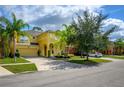 Community view showing homes with palm trees and driveway at 221 Las Fuentes Dr, Kissimmee, FL 34746