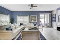 Open living room with white sectional sofa and blue walls at 690 Pebble Beach Dr, Davenport, FL 33896