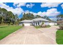 Two-story home with a long driveway and landscaped yard at 12009 Eagle Point Ct, Leesburg, FL 34788