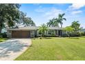 Ranch style home with a wooden garage door and landscaped yard at 4205 Waterfront Pkwy, Orlando, FL 32806