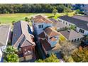 An elevated view of a three story house next to a golf course at 1169 Castle Pines Ct, Reunion, FL 34747