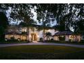 Two story luxury home with palm trees and circular driveway at night at 5121 Latrobe Dr, Windermere, FL 34786