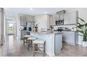 Modern kitchen with gray cabinets, granite counters, and stainless steel appliances at 2563 Sage Valley Way, Winter Haven, FL 33884