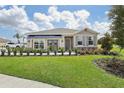 One-story home with gray siding, brown accents, and a two-car garage at 5945 Cliffbow Loop, Leesburg, FL 34748
