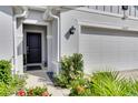 Home's exterior entryway with a dark door and landscaping at 16559 Centipede St, Clermont, FL 34714