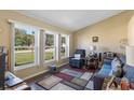 Living room with hardwood floors, comfortable seating, and large windows at 3231 Bretton Woods Ter, Deltona, FL 32725