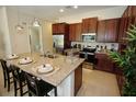 Modern kitchen with granite countertops, stainless steel appliances, and an island at 314 Captiva Dr, Davenport, FL 33896