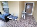 Front porch with tiled floor, metal chairs, and small table at 602 Milan Dr, Kissimmee, FL 34758