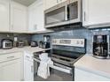 Modern kitchen with stainless steel appliances and white cabinets at 3161 Paradox Cir # 101, Kissimmee, FL 34746