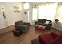 Living room with hardwood floors, comfy seating, and a wood storage chest at 3235 Bellingham Dr, Orlando, FL 32825