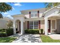 Two story tan townhome with red shutters and a paved driveway at 2364 Silver Palm Dr, Kissimmee, FL 34747